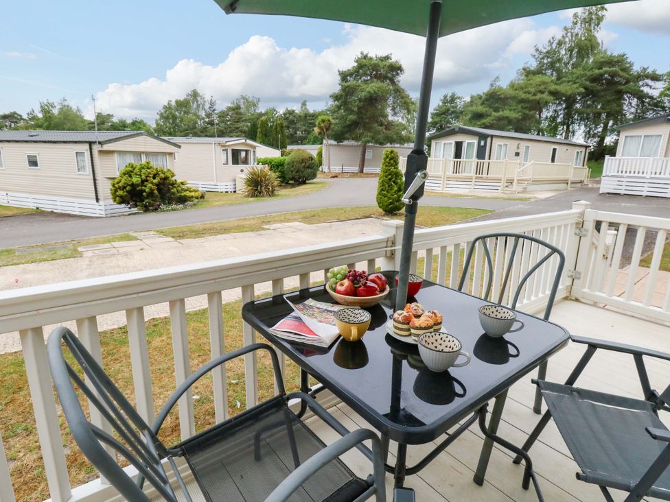 An outdoor patio area with a table and chairs at Foxglove 4 in Ringwood