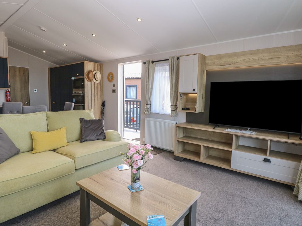 A living room with a sofa and a television at Plot 34 in Bacton