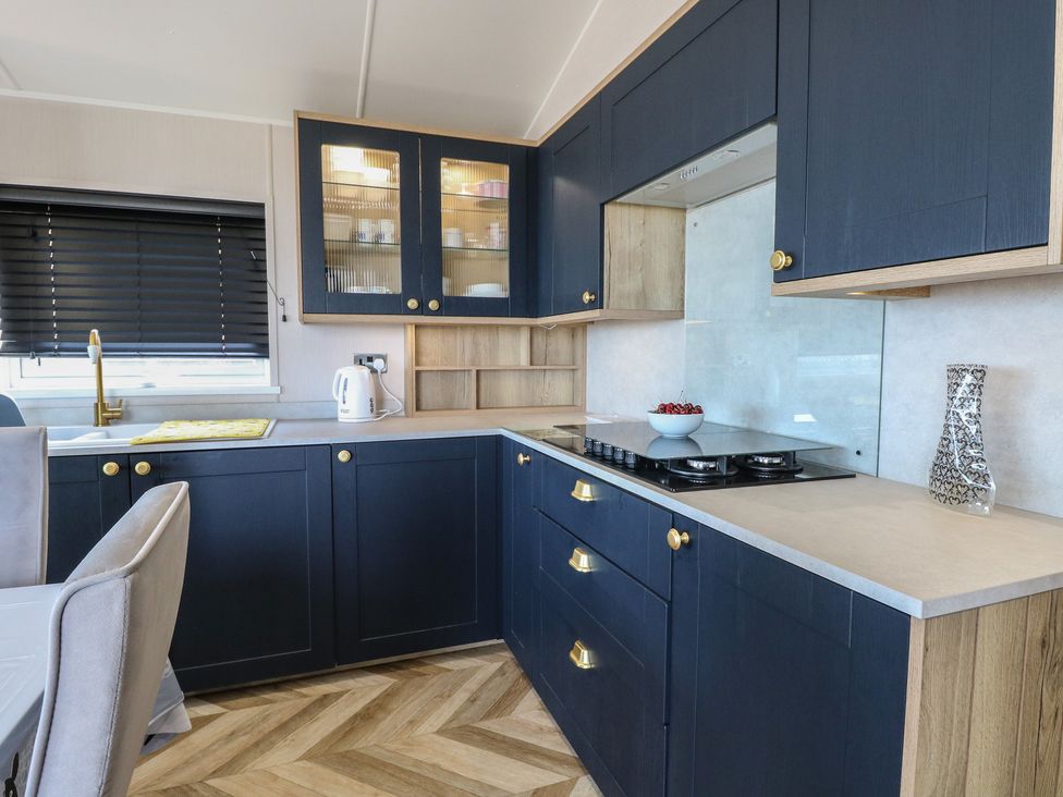 A kitchen with cabinets and a gas stove at Plot 34 Bacton