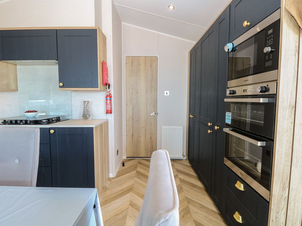 A kitchen with cabinets, stove, and ovens at Plot 34 in Bacton