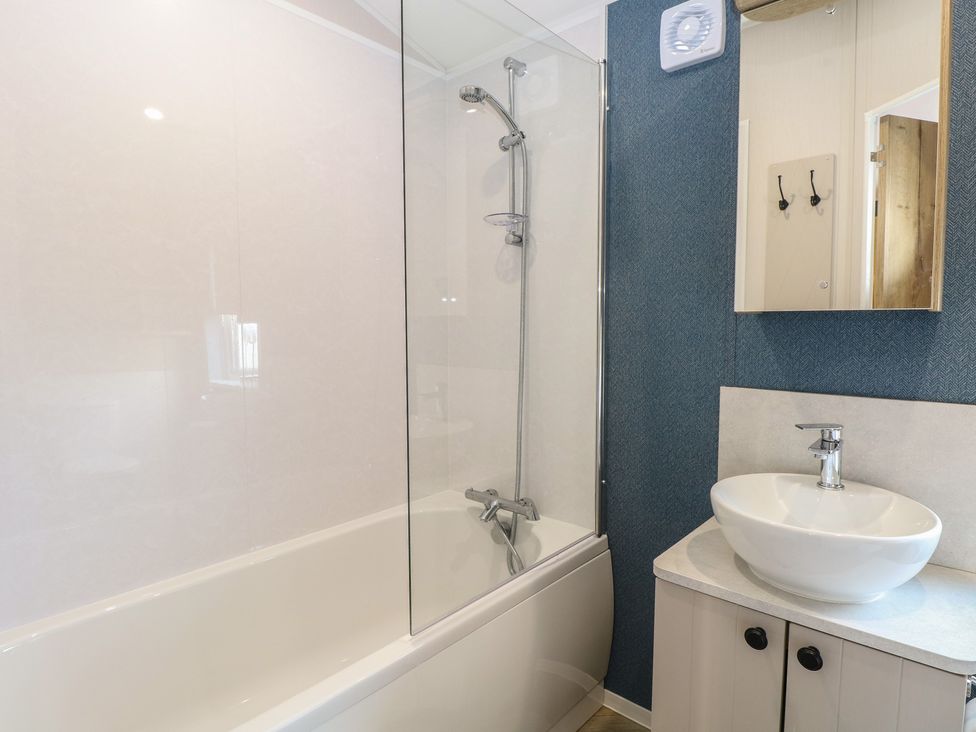 A bathroom with a bath tub and a sink at Plot 34 Bacton