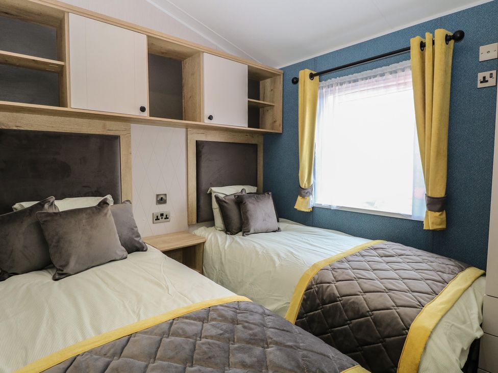 A bedroom with two beds and a window at Plot 34 in Bacton