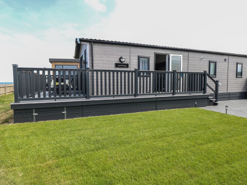 An outdoor area with a deck and grass at Plot 34 in Bacton