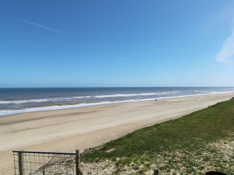 A beach with sand and ocean waves at Plot 34 in Bacton