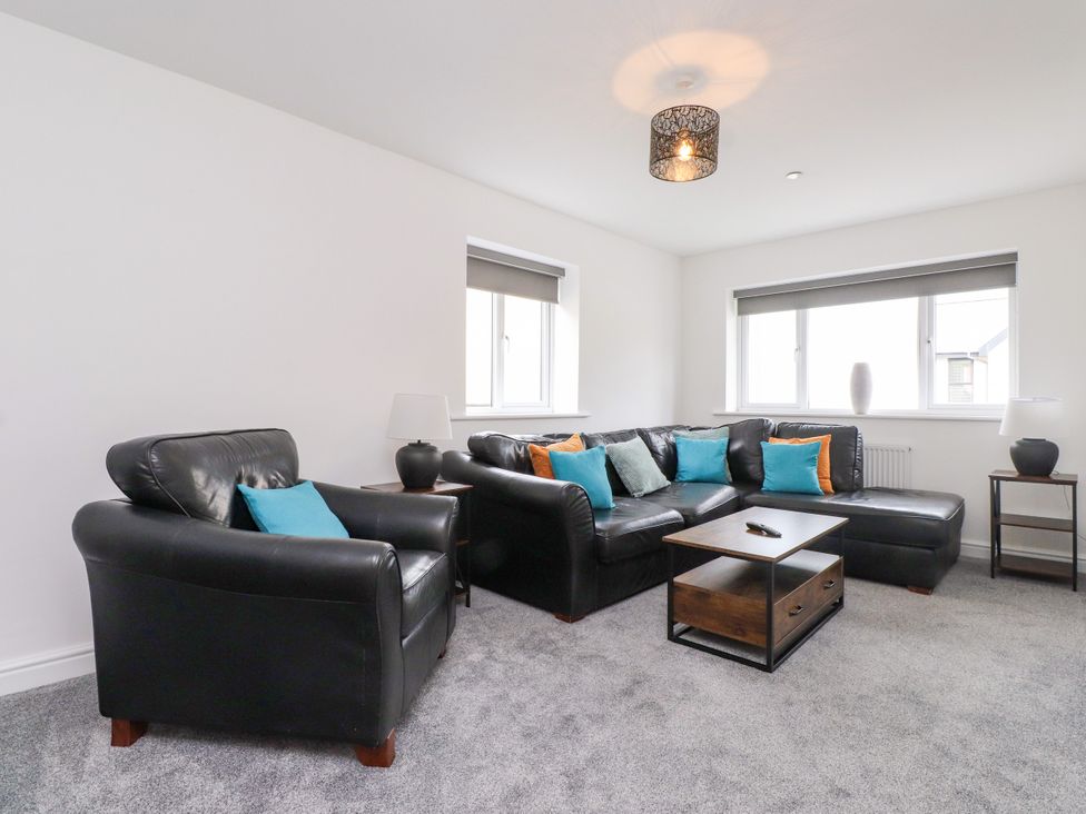 A living room with a sofa and armchairs at 95 Cae America in Llanfairfechan