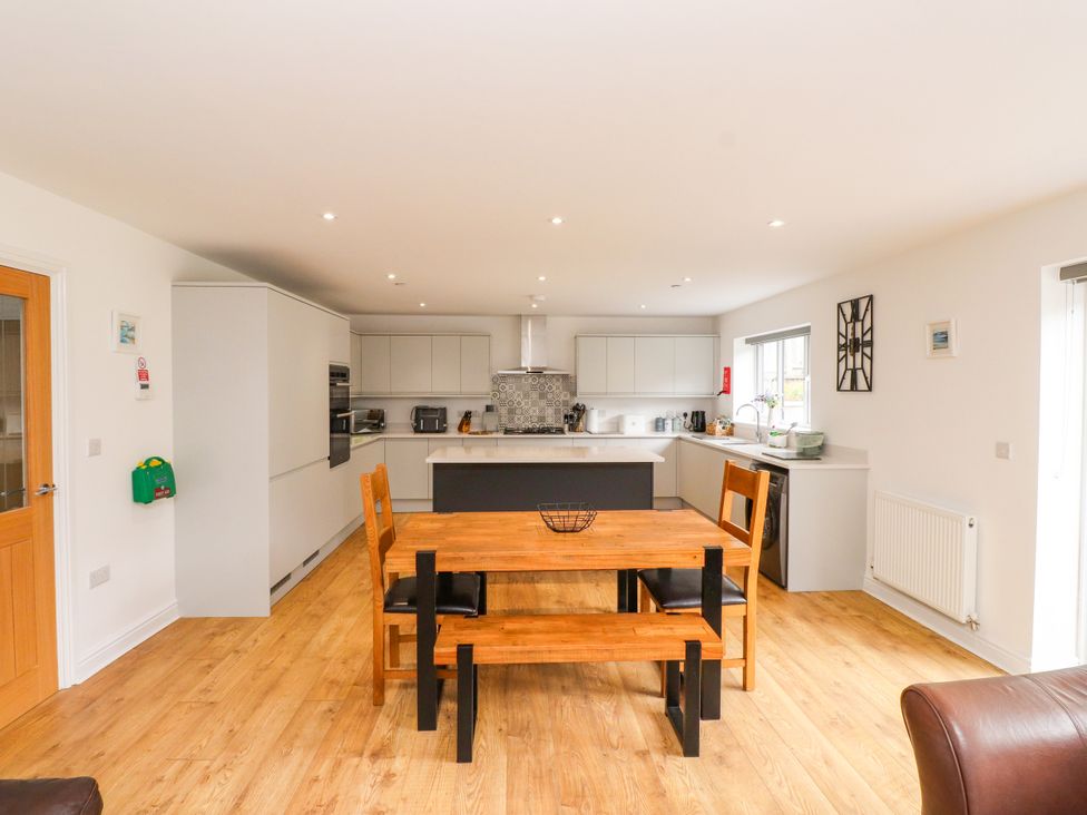 A kitchen with dining table and chairs at 95 Cae America in Llanfairfechan