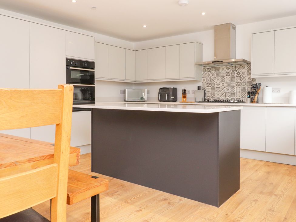 A kitchen with cabinets, stove, microwave at 95 Cae America Llanfairfechan