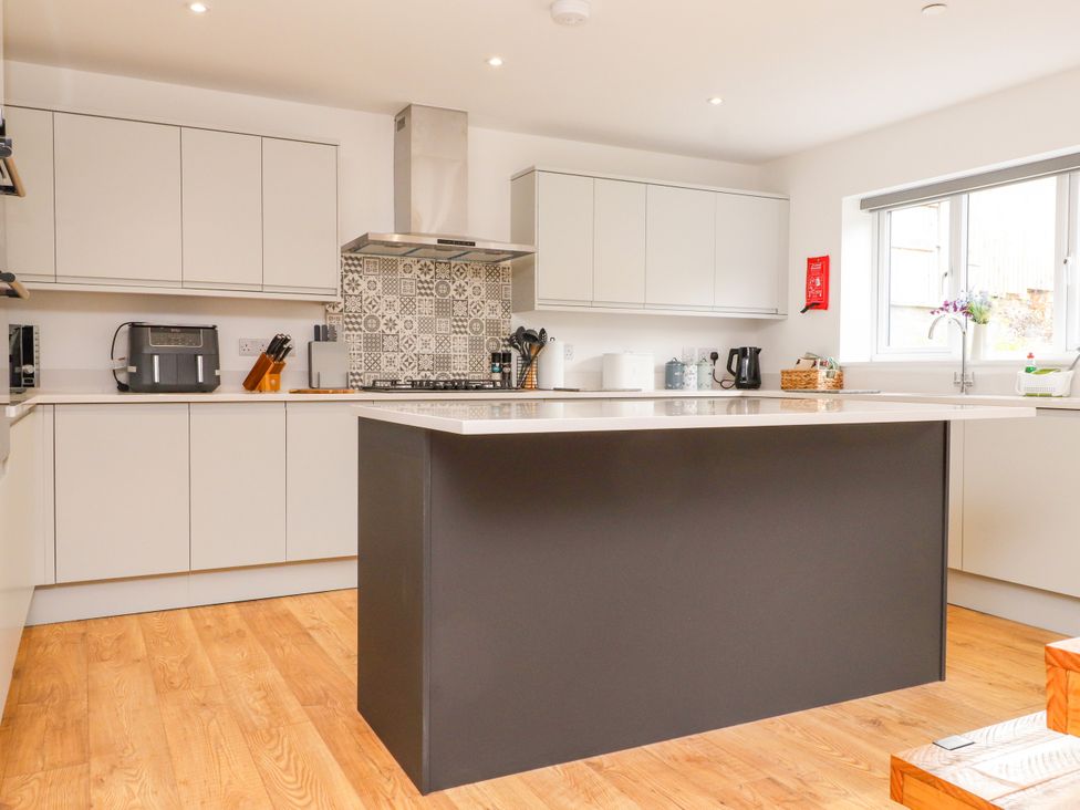A kitchen with cabinets and a stove at 95 Cae America in Llanfairfechan