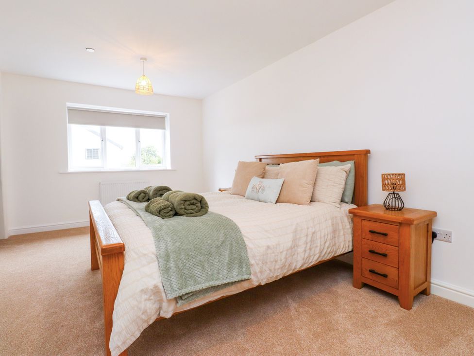 A bedroom with a bed and nightstand at 95 Cae America Llanfairfechan