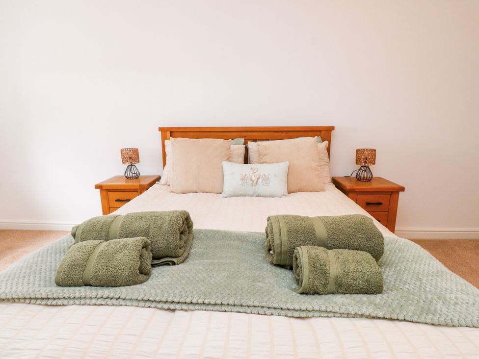 A bedroom with a bed and decorative items at 95 Cae America in Llanfairfechan