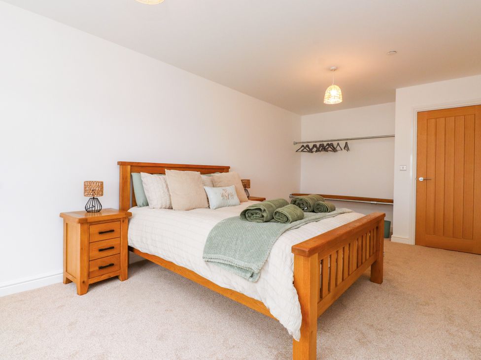 A bedroom with a bed and bedside table at 95 Cae America Llanfairfechan