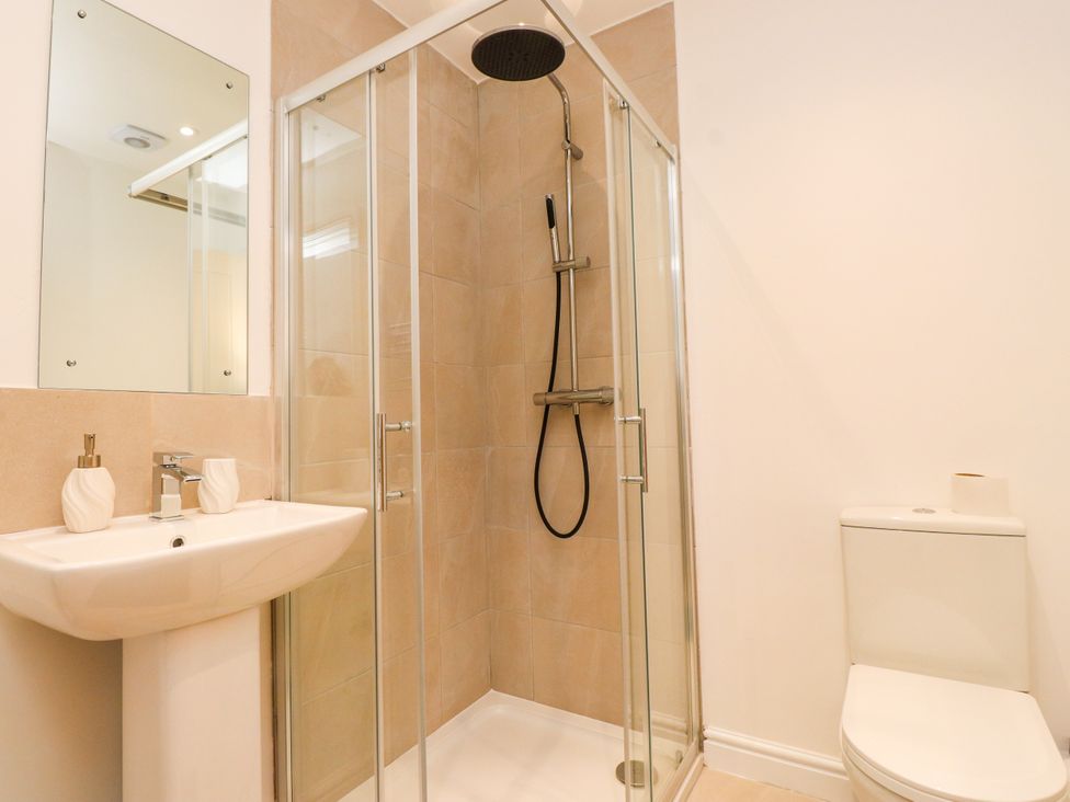 A bathroom with a shower, sink, and toilet at 95 Cae America in Llanfairfechan