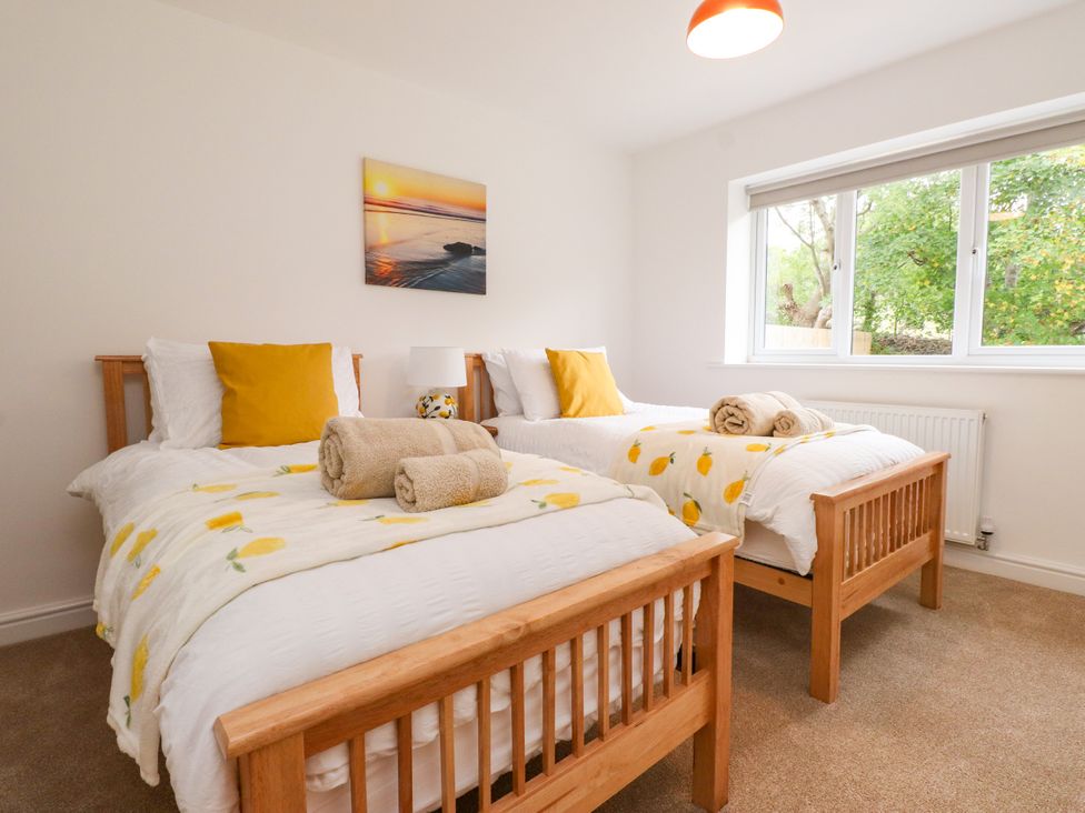 A bedroom with two beds and a window at 95 Cae America Llanfairfechan