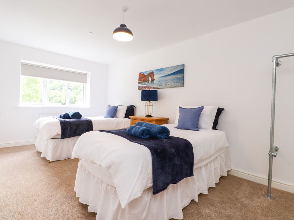 A bedroom with two single beds and a window at 95 Cae America Llanfairfechan