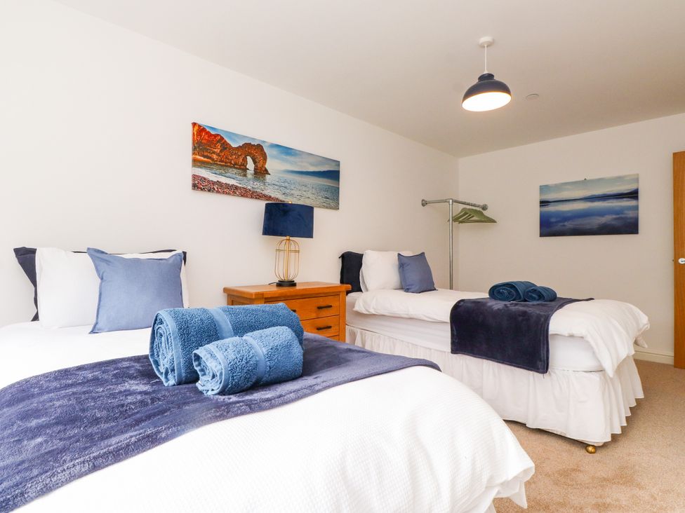 A bedroom with two beds and towels at 95 Cae America in Llanfairfechan