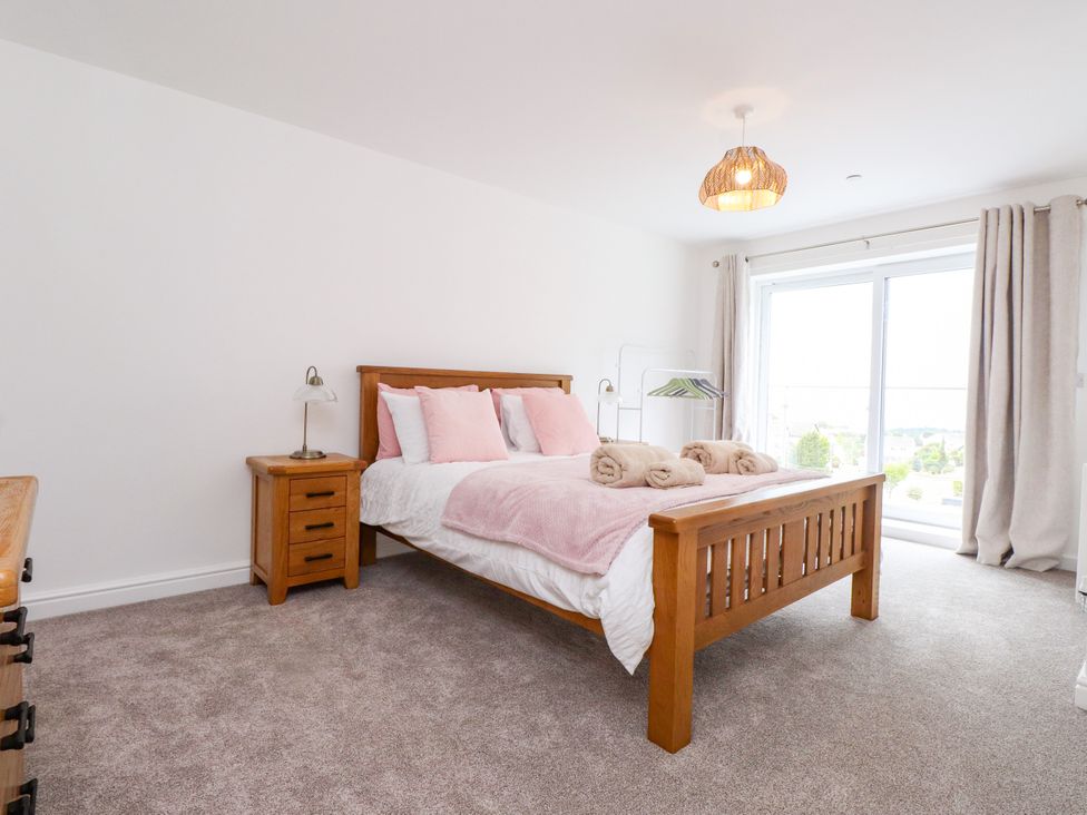 A bedroom with a bed and nightstand at 95 Cae America, Llanfairfechan