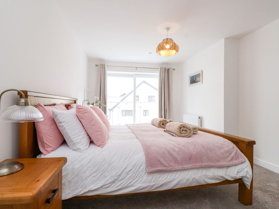 A bedroom with a bed and a bedside table at 95 Cae America in Llanfairfechan