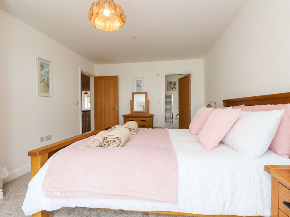 A bedroom with a bed and mirror at 95 Cae America in Llanfairfechan
