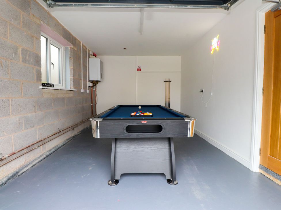 A games room with a pool table and cue rack at 95 Cae America Llanfairfechan