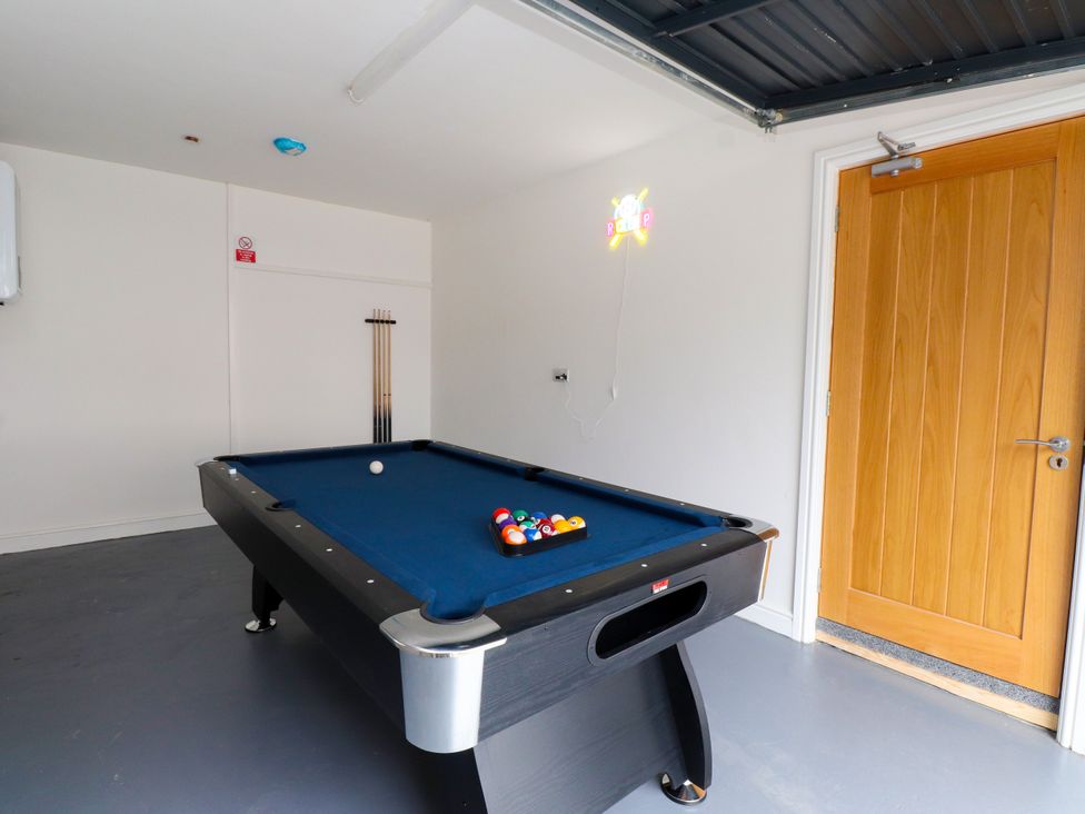 A game room with a pool table and door at 95 Cae America Llanfairfechan