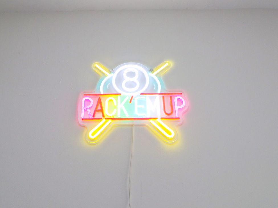 A neon sign that says Rack 'Em Up with number 8 at 95 Cae America in Llanfairfechan