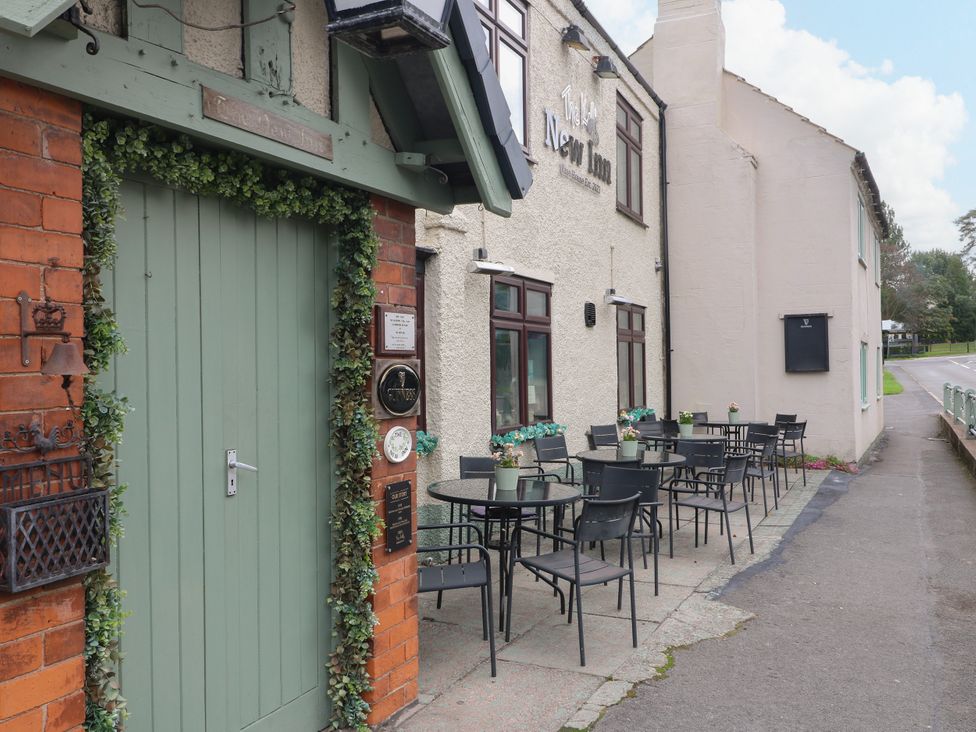 An outdoor seating area with tables and chairs at The New Inn in Coalville