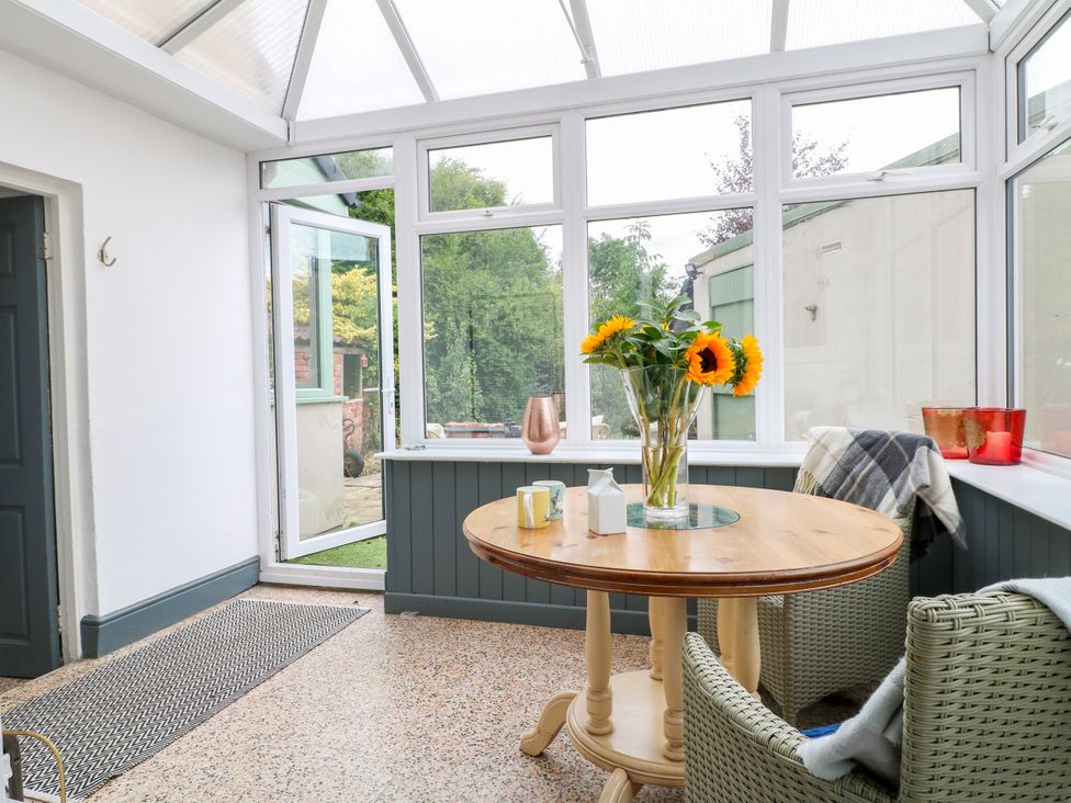 A conservatory with a table and chairs at Next Door No. 4 in Coalville