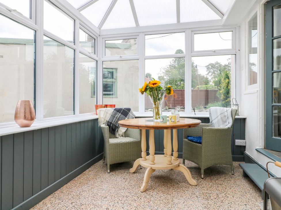 A conservatory with a table and chairs at Next Door No. 4 in Coalville