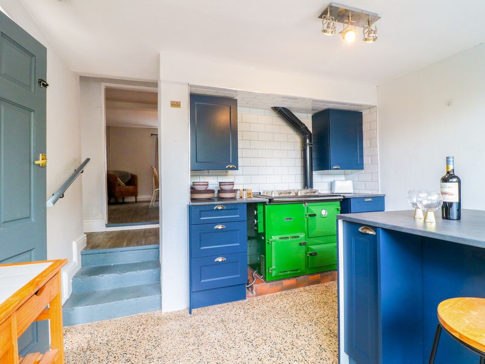 A kitchen with green stove and blue cabinets at Next Door No. 4 in Coalville
