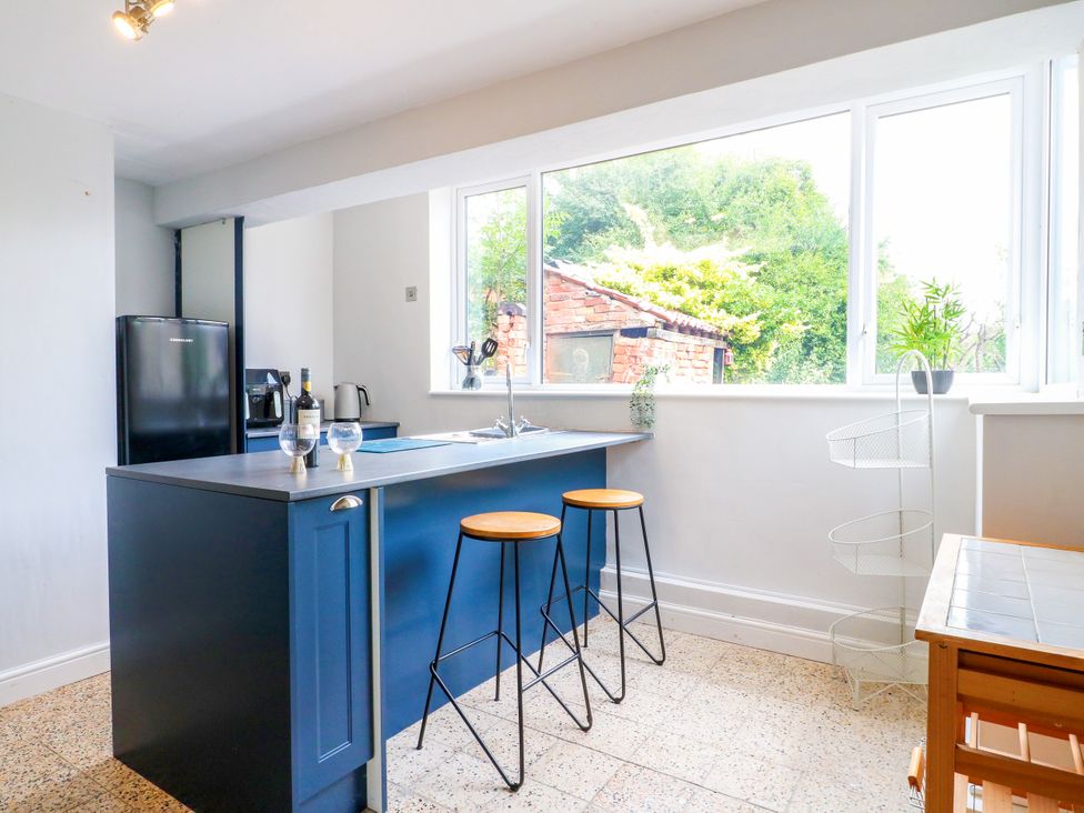 A kitchen with a counter and bar stools at Next Door No. 4 Coalville