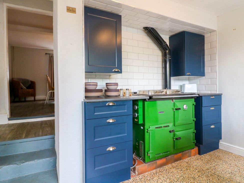 A kitchen with a green cooker and blue cabinets at Next Door No. 4 Coalville