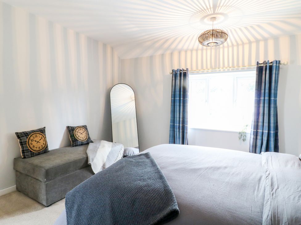 A bedroom with a bed, mirror and curtains at Next Door No. 4 in Coalville