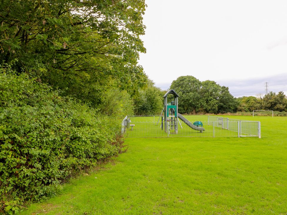 A playground with slide and fence in an outdoor area at Next Door No. 4 Coalville