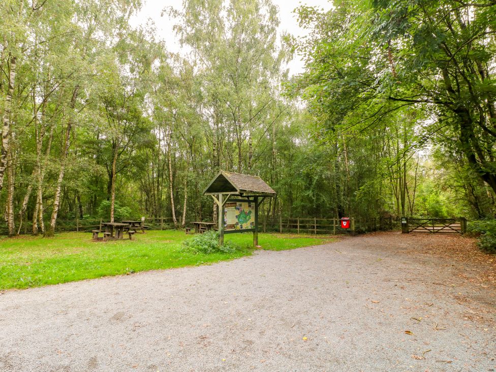 An outdoor area with picnic tables and a map sign at Next Door No. 4 in Coalville