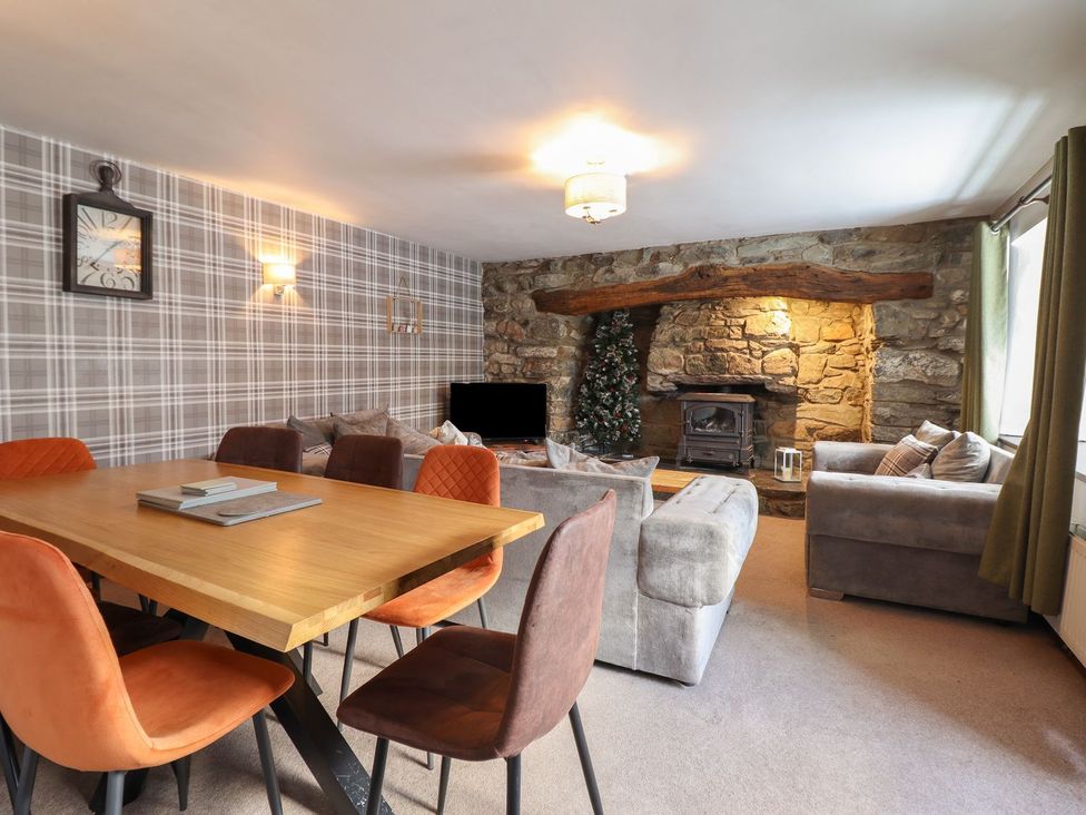 A living room with a dining table and sofas at Cader Cottage in Dolgellau