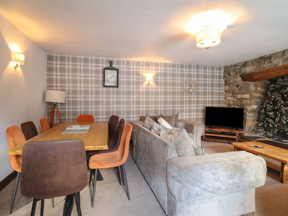 A living room with a sofa and dining table at Cader Cottage in Dolgellau