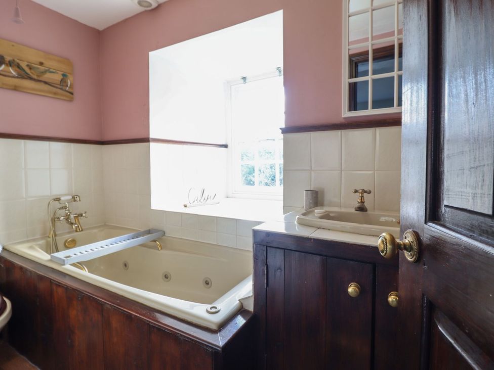 A bathroom with a bathtub and sink at Cader Cottage Dolgellau
