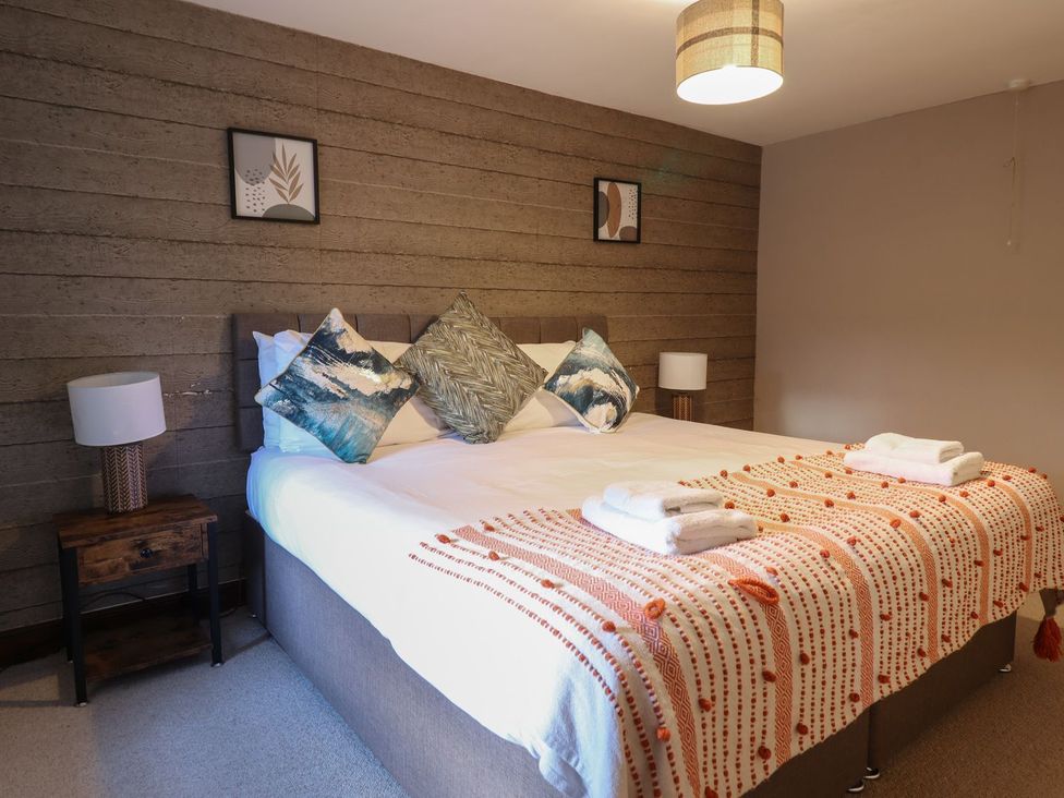 A bedroom with a bed and nightstand at Cader Cottage in Dolgellau