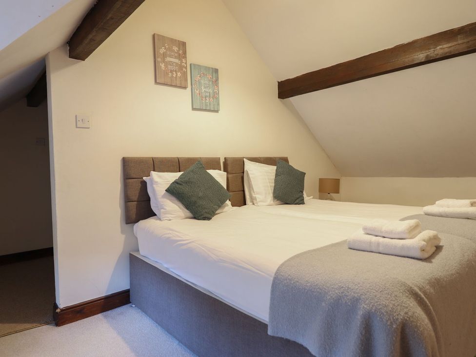 A bedroom with two beds and wall decorations at Cader Cottage Dolgellau