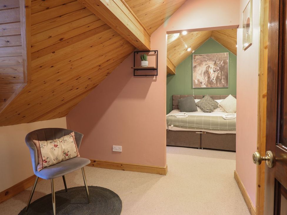 A bedroom with a bed and chair at Cader Cottage in Dolgellau
