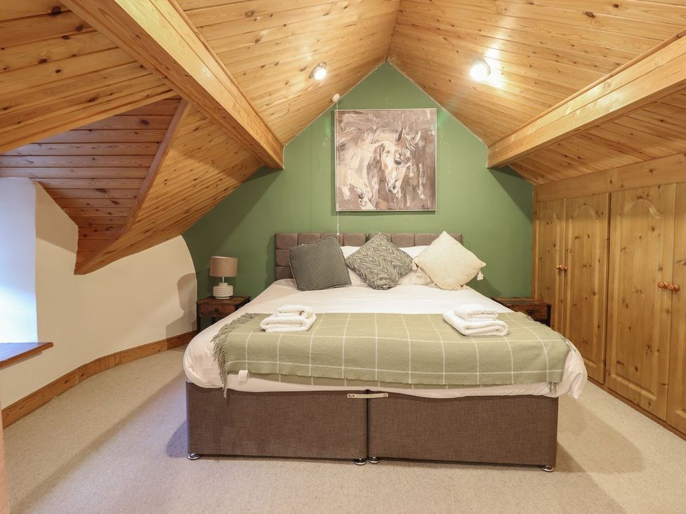 A bedroom with a bed and nightstand at Cader Cottage in Dolgellau