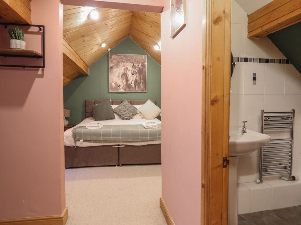 A bedroom with a bed and washbasin at Cader Cottage Dolgellau