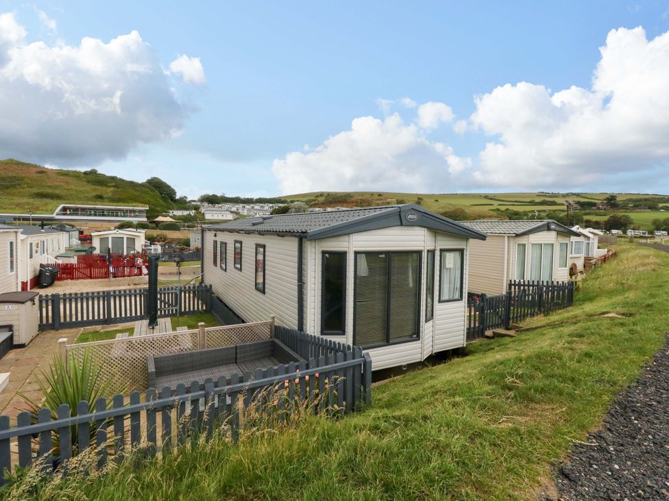 A mobile home with a fenced garden area at Caravan A7 in Bridport