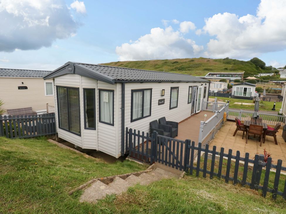 A caravan with a deck and fence at Caravan A7 in Bridport