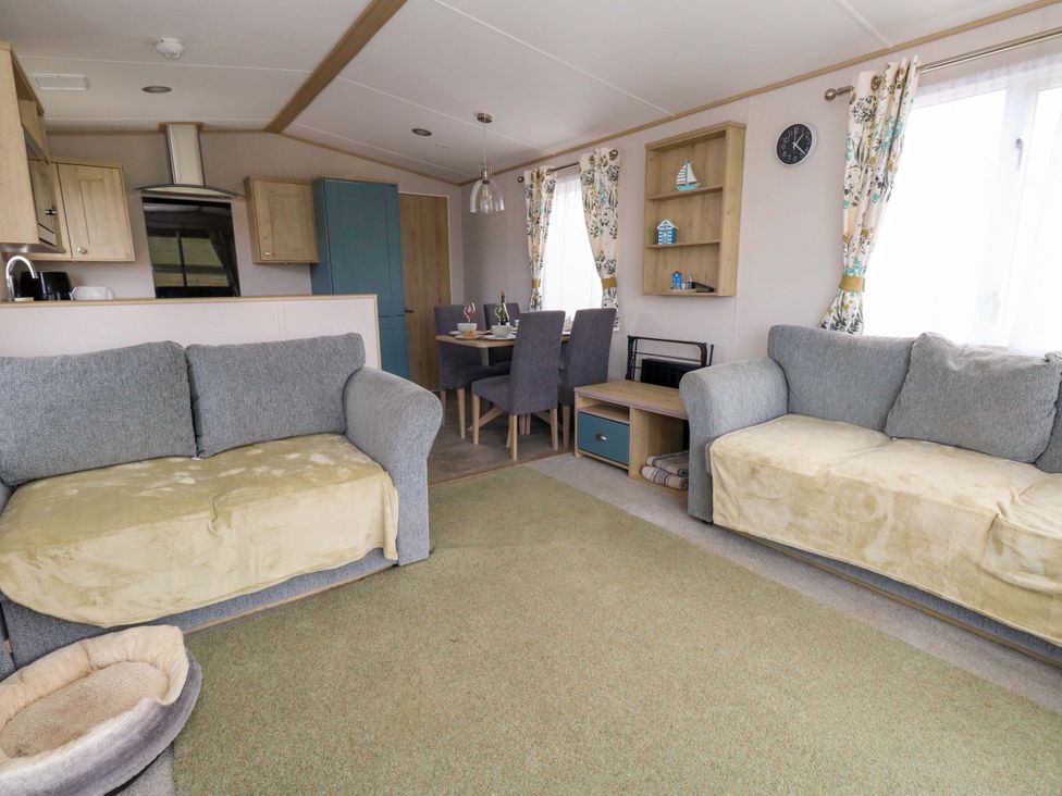 A living room with sofas and dining table at Caravan A7 in Bridport