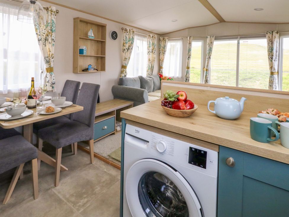 A kitchen with dining table and chairs at Caravan A7 in Bridport