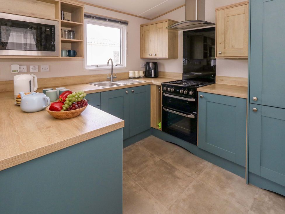 A kitchen with cabinets and countertop at Caravan A7 in Bridport