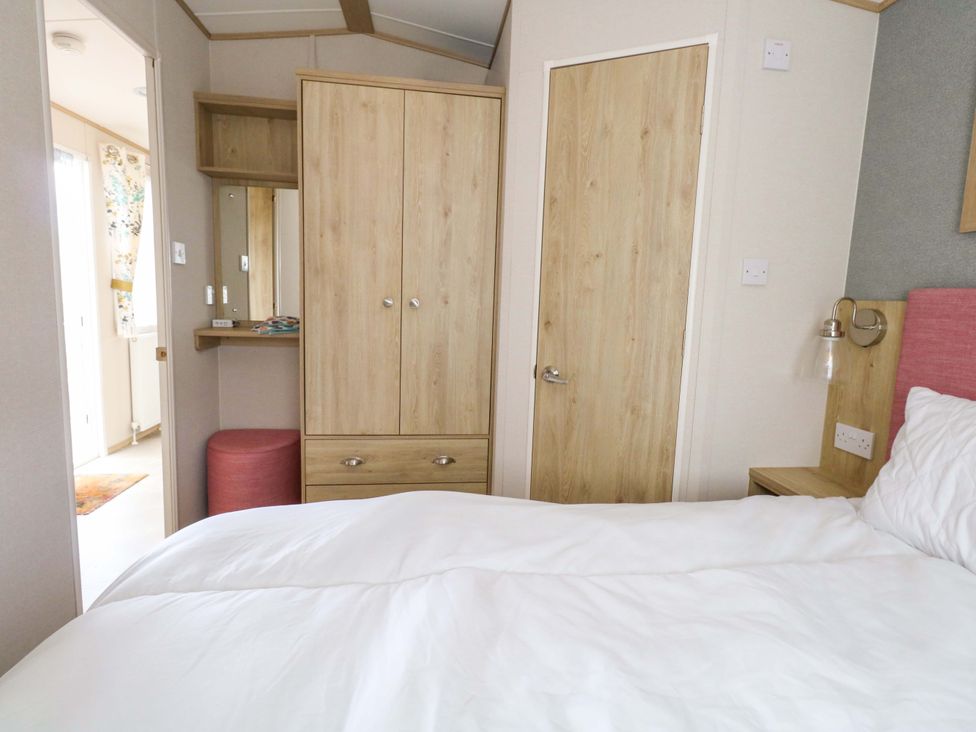 A bedroom with a bed and wardrobe at Caravan A7 in Bridport