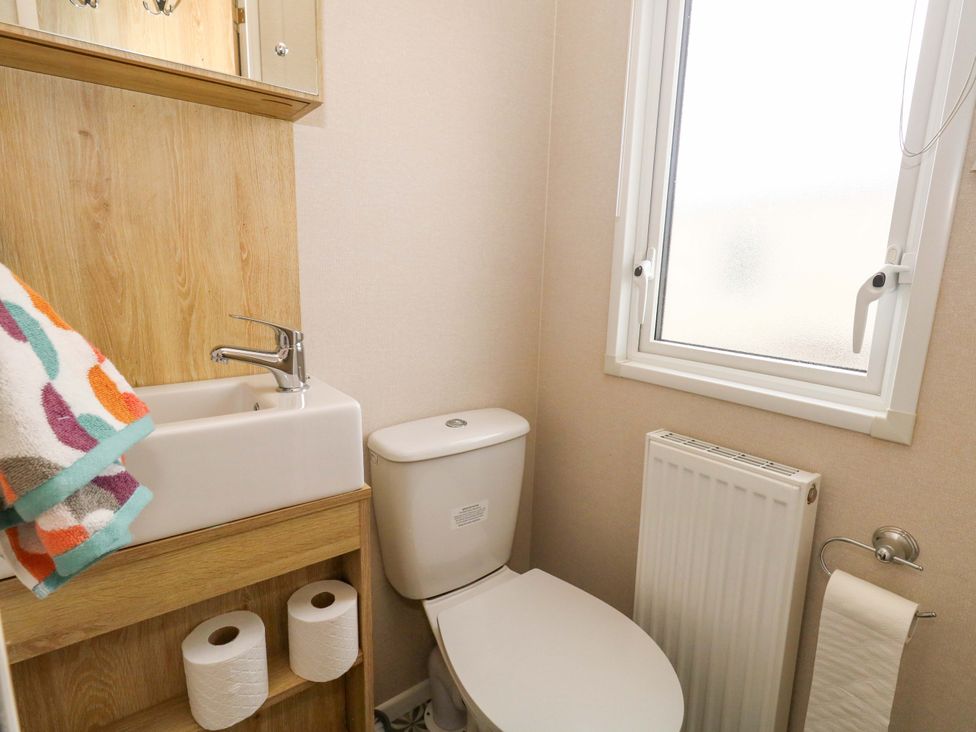 A bathroom with a toilet and sink at Caravan A7 in Bridport