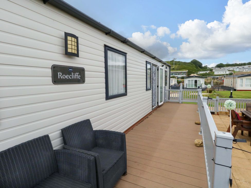 An outdoor area with seating and a nameplate at Caravan A7 in Bridport
